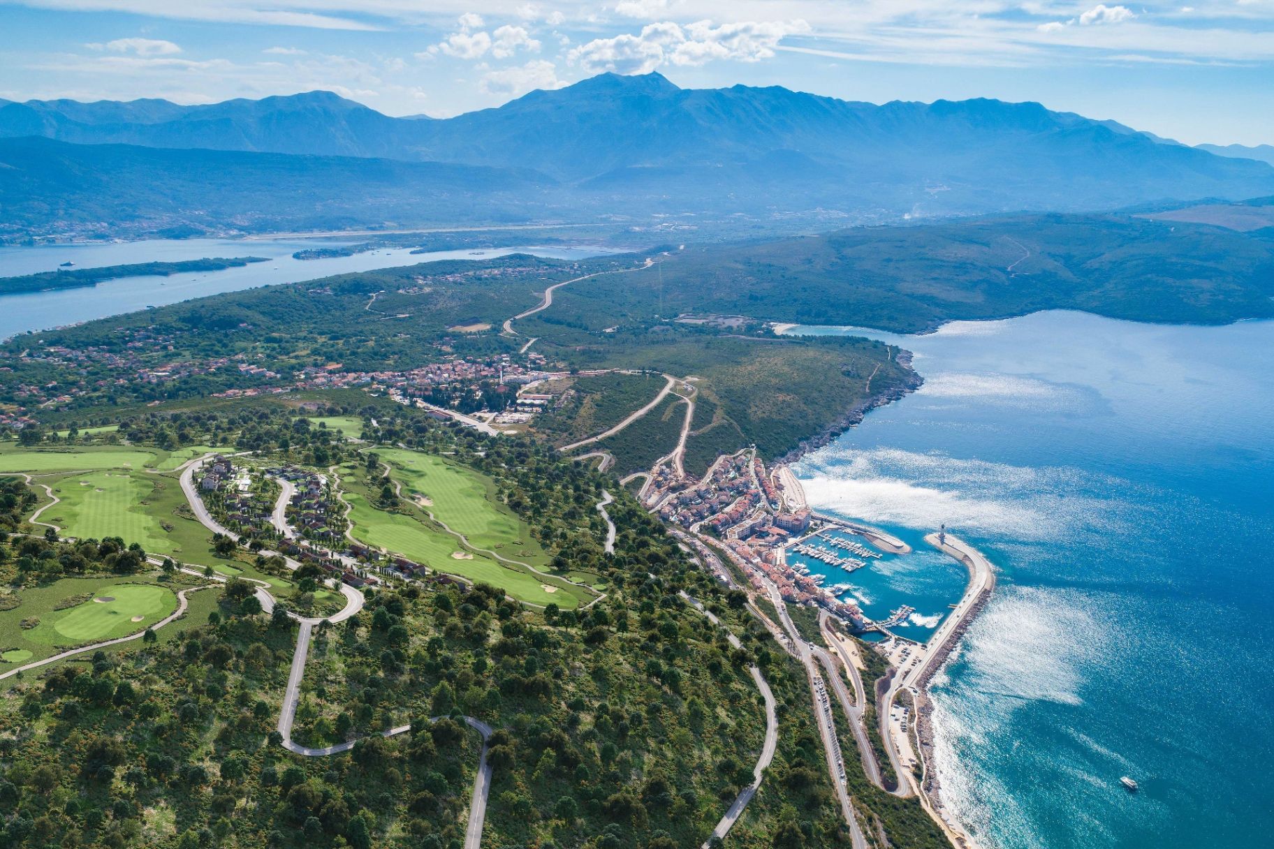 Aerial view of Boka Bay coastline with mountains and marina - where to buy property in Montenegro